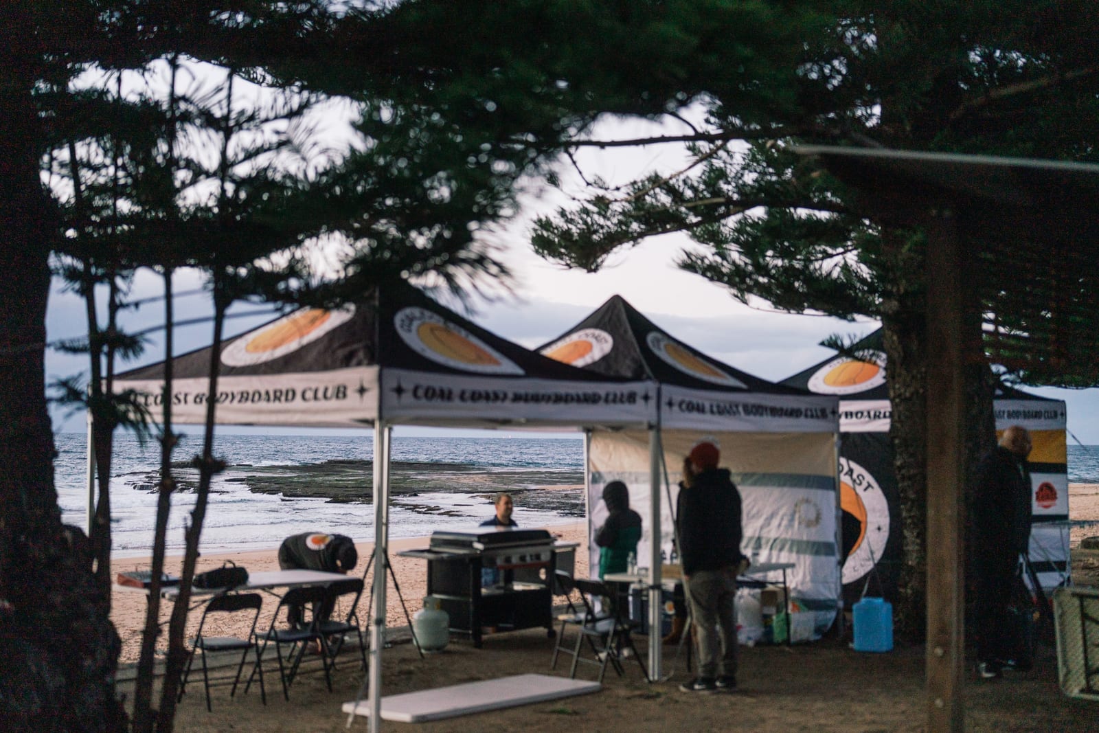 Coal Coast Bodyboard Club marquees set up under the Norfolk pines above the beach