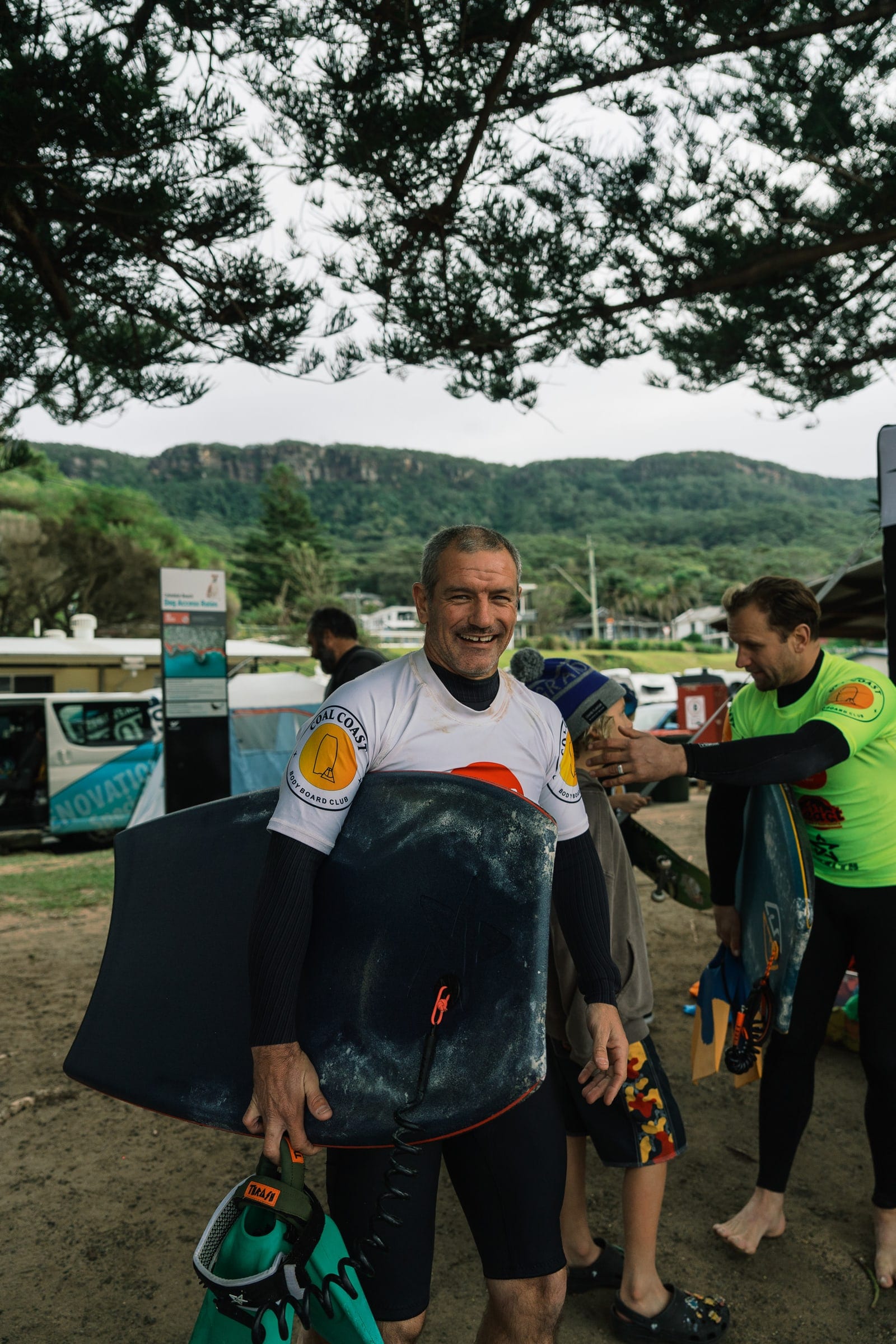 Club members in competition jerseys celebrating together outside the marquees